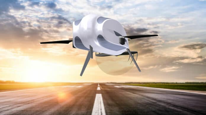 Blainjett's hemi-rotor drone cruising by a runway with main rotors halted in an outward Fixed position.