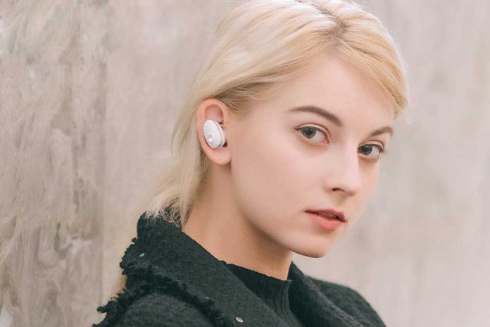 A girl wearing Mugo Pro earbuds