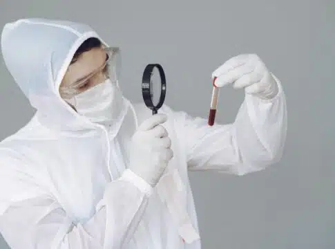 Man in protective suit and glasses on grey wall