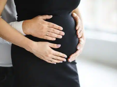 Man holds hands for her pregnant wife belly